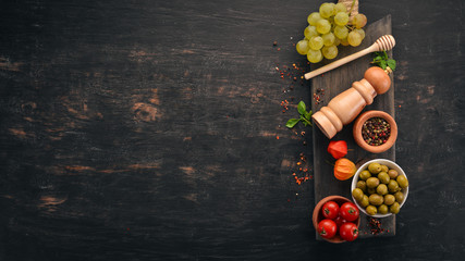 Food Background. Snack on a wooden board. Top view. On a black wooden background. Free space for your text.