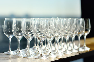 Lots of crystal clear empty wine glasses at the bar.