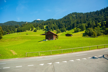 Chatka przy drodze na łące na tle gór © Anna Mazur