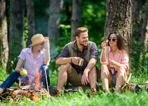 Camping and hiking. Halt for snack during hiking. Company friends relaxing and having snack picnic nature background. Company hikers relaxing at picnic forest background. Relax in nature environment