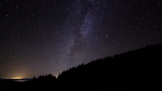 Milky Way Galaxy astronomy time lapse stars moving above mountain valley light pollution near horizon bright night campsite summer view of milkyway move across sky science space universe presentation
