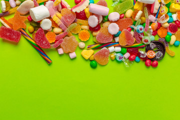 Colorful candies on green background