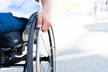 cropped image of man using wheelchair on street - obrazy, fototapety, plakaty