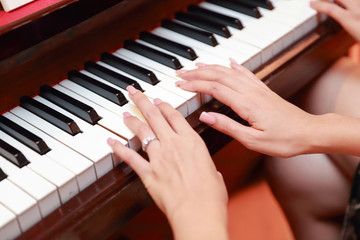 Fototapeta premium Close up woman hands playing piano in Christmas party