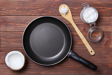 Frying pan and coconut oil on a wooden table. Top view. fry in coconut oil.