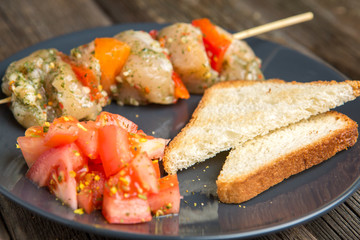 Raw skewer of meat on a plate.