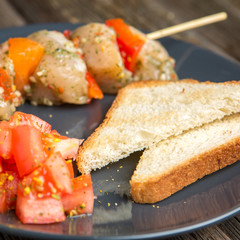 Raw skewer of meat on a plate.