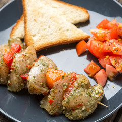 Raw skewer of meat on a plate.