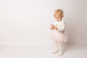 funny Caucasian little girl feeling angry as she lost game. Mad female child having displeased look because of low battery on cell phone or bad cellular connection