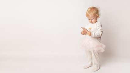 funny Caucasian little girl feeling angry as she lost game. Mad female child having displeased look because of low battery on cell phone or bad cellular connection