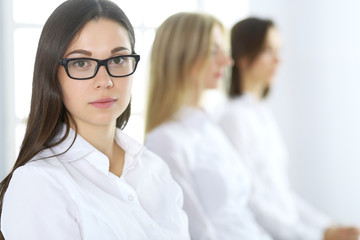 Attractive businesswoman at meeting or conference against the background of colleagues. Group of business people at work. Portrait of lawyer or secretary