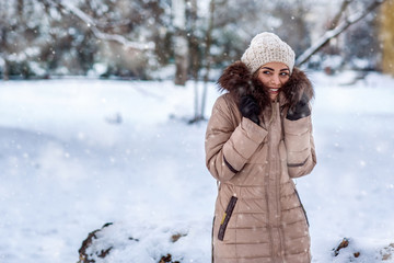 Fototapeta na wymiar winter holidays, Christmas and people concept – Smiling girl on a winter walk in winter time at nature..