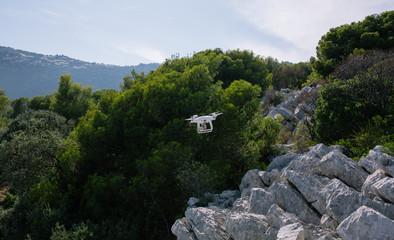Drone, flyingon the white rocks against the blue sky quadrocopter fpv fly camera rc controller