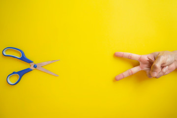 Rock Paper Scissors on yellow background, Top View, Copy-space.