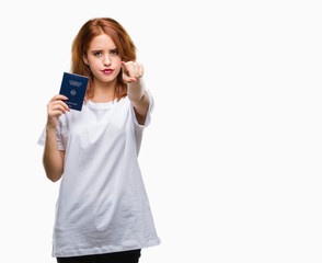 Fototapeta premium Young beautiful woman holding passport of germany over isolated background pointing with finger to the camera and to you, hand sign, positive and confident gesture from the front