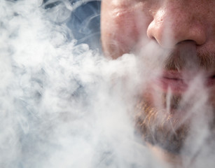 Smoke from the nose of a man from a cigar