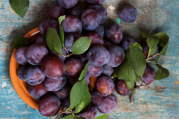 Fototapeta premium Plum plate on wooden background.
