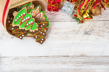 Beautiful Christmas composition and decoration with baked Christmas gingerbread cookies in paper bag on light wooden background, flat lay, top view, copy space (text space)