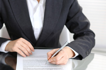 Close-up of female hands with pen over document of contact, business concept
