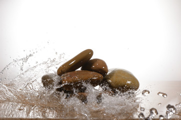 Agua cayendo sobre unas piedras con fondo blanco