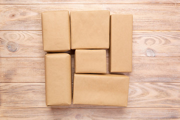 Brown mail package parcel blank for you design. Cardboard box on a wooden background
