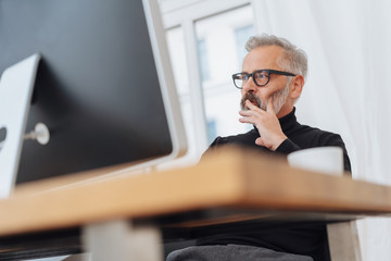 Businessman reading a monitor with a pensive look