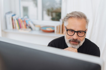 Pensive businessman reading his desktop monitor