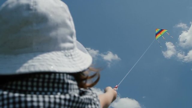 Little girl raising a kite in the sky - POV