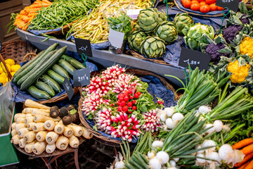 Variety of beautifully organized fruits and vegetables on the counter of the market place