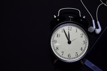 black vintage alarm clock on the black background