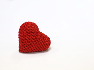 Red knitted heart isolated on white background. Concept for romantic love, blood donation, heart disease, health care, Valentine's day