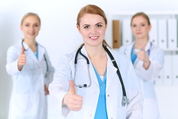 Groupe of medicine doctors show OK sign with thumb up. Success and high level service in health care, best treatment and customer loyalty and physical concept. Copy space for advertisement