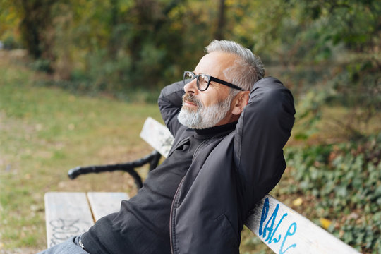 Man relaxing on a park bench with closed eyes