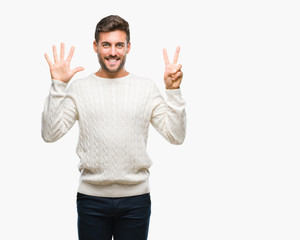 Young handsome man wearing winter sweater over isolated background showing and pointing up with fingers number seven while smiling confident and happy.
