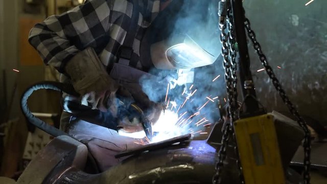 industrial worker welds component at workplace in a steel construction company // Arbeiter Industrie Schweißer