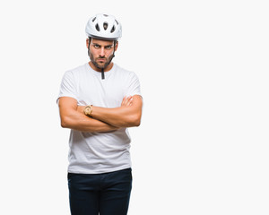 Young handsome man wearing cyclist safety helmet over isolated background skeptic and nervous, disapproving expression on face with crossed arms. Negative person.