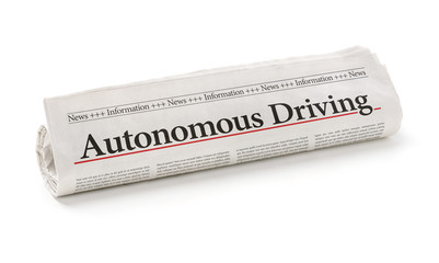 Rolled newspaper with the headline Autonomous Driving