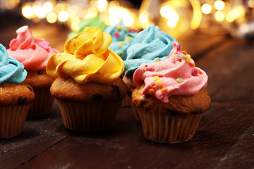 Tasty cupcakes on christmas winter background. Birthday cupcake in rainbow colors.