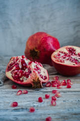 Pomegranate and pomegranate seeds on a wooden table