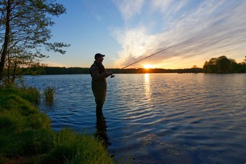 Angler catching the fish during sunset