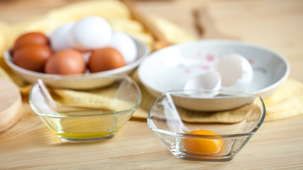 Obraz na płótnie Canvas separate eggs white and yolks, egg shells at the background