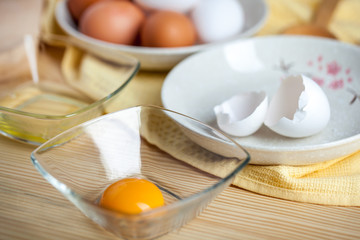 separate eggs white and yolks, egg shells at the background
