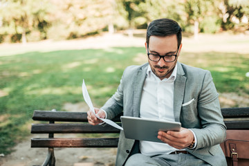 Handsome business man working in the park.