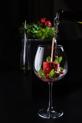Pour sparkling wine into a glass with fruit sorbet