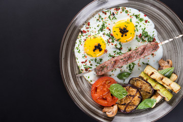 Fried eggs with kebab and grilled vegetables