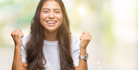 Young beautiful arab woman over isolated background celebrating surprised and amazed for success with arms raised and open eyes. Winner concept.