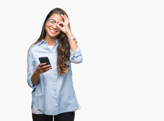 Young beautiful arab woman texting using smartphone over isolated background with happy face smiling doing ok sign with hand on eye looking through fingers