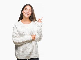 Young beautiful arab woman wearing winter sweater over isolated background with a big smile on face, pointing with hand and finger to the side looking at the camera.