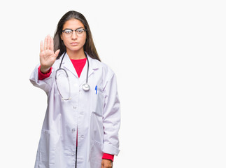 Young arab doctor woman over isolated background doing stop sing with palm of the hand. Warning expression with negative and serious gesture on the face.