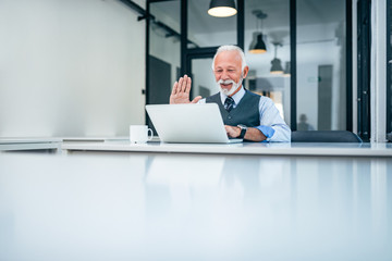 Senior businessman having video call on laptop. Copy space.